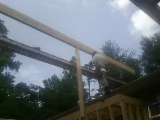 Carpenter setting a ridge beam over a new addition frame — Ice Dam Removal by Roofing Brothers in Moseley
