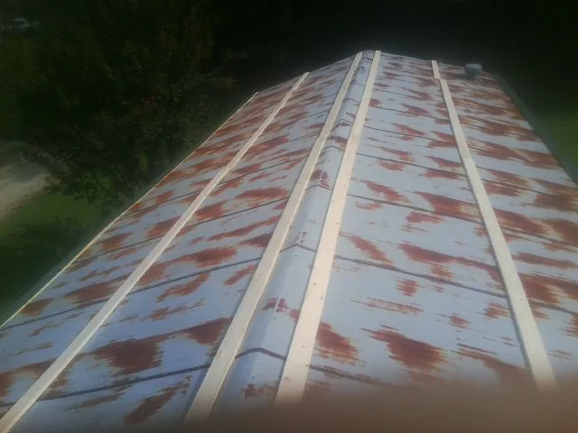 Rusted metal roof panels with new wood purlins before replacement — Storm Damage Roof Repair in Moseley by Roofing Brothers