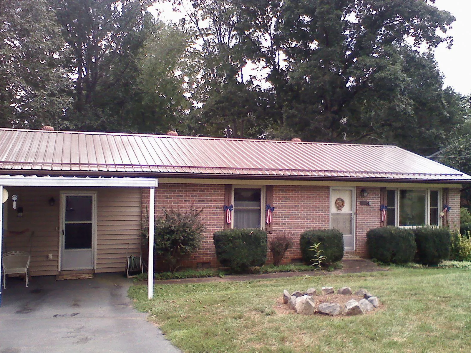 Bronze metal roof and carport on a brick ranch home — Roof Repair work by our crew in Moseley